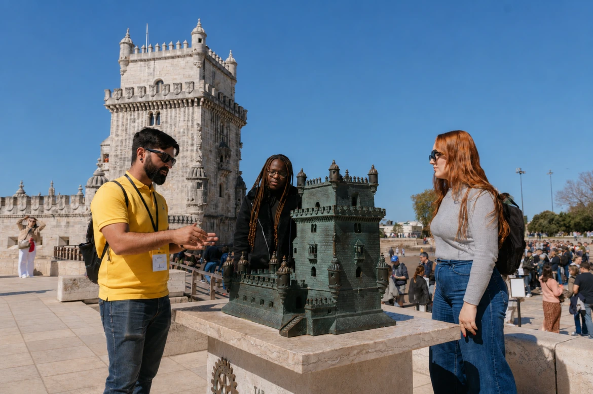 Viajantes a descobrir a Torre de Belém, Património Mundial da UNESCO, com um guia local durante uma visita turística em Lisboa