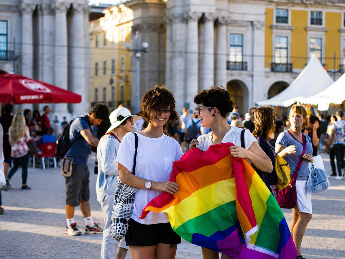 Viajantes a celebrar a diversidade na Praça do Comércio durante uma visita guiada inclusiva em Lisboa