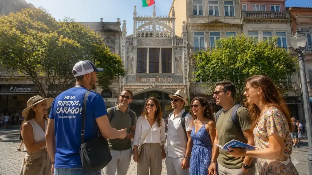 Guia fala com visitantes em frente à Livraria Lello, no Porto, com a fachada neogótica da livraria ao fundo.