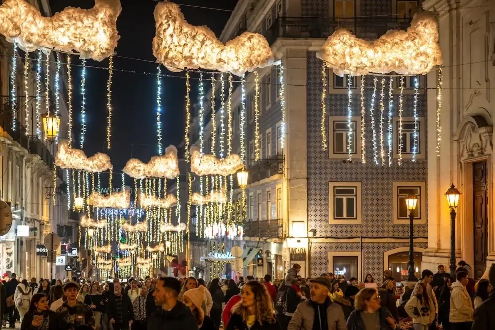Crowded street in central Lisbon decorated with illuminated Christmas displays and hanging lights