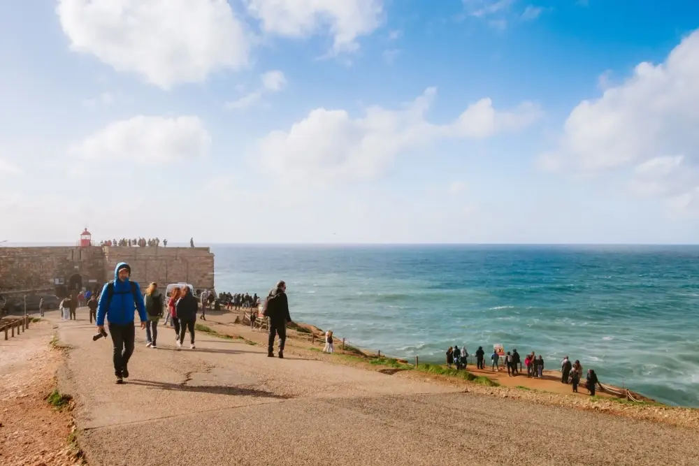 Costa atlântica da Nazaré com visitantes junto ao Forte de São Miguel Arcanjo, sobre a zona conhecida pelas ondas gigantes da Nazaré.