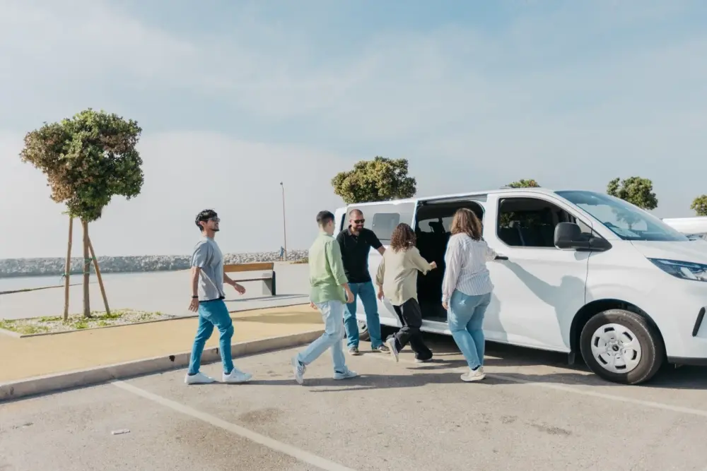 Visitantes entram numa carrinha de tour junto à costa da Nazaré durante uma visita ao litoral português.