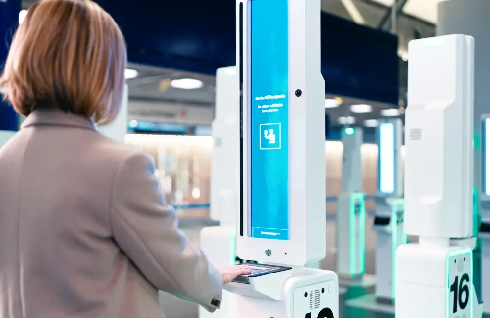 Traveller using an automated passport control kiosk at an airport border checkpoint.