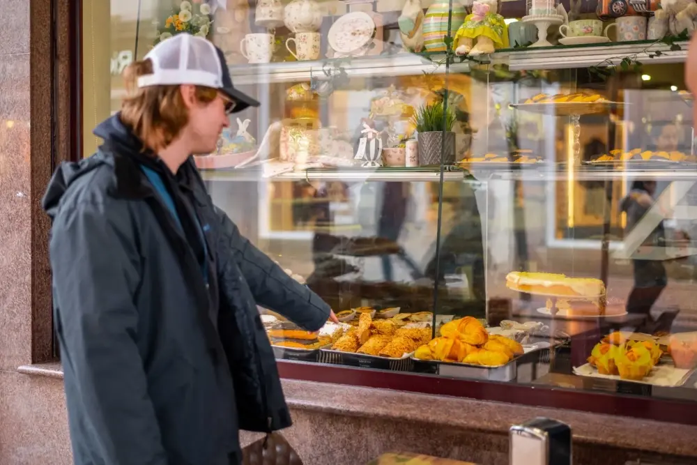 Visitor choosing from a display of traditional pastries during a food tour in Porto.
