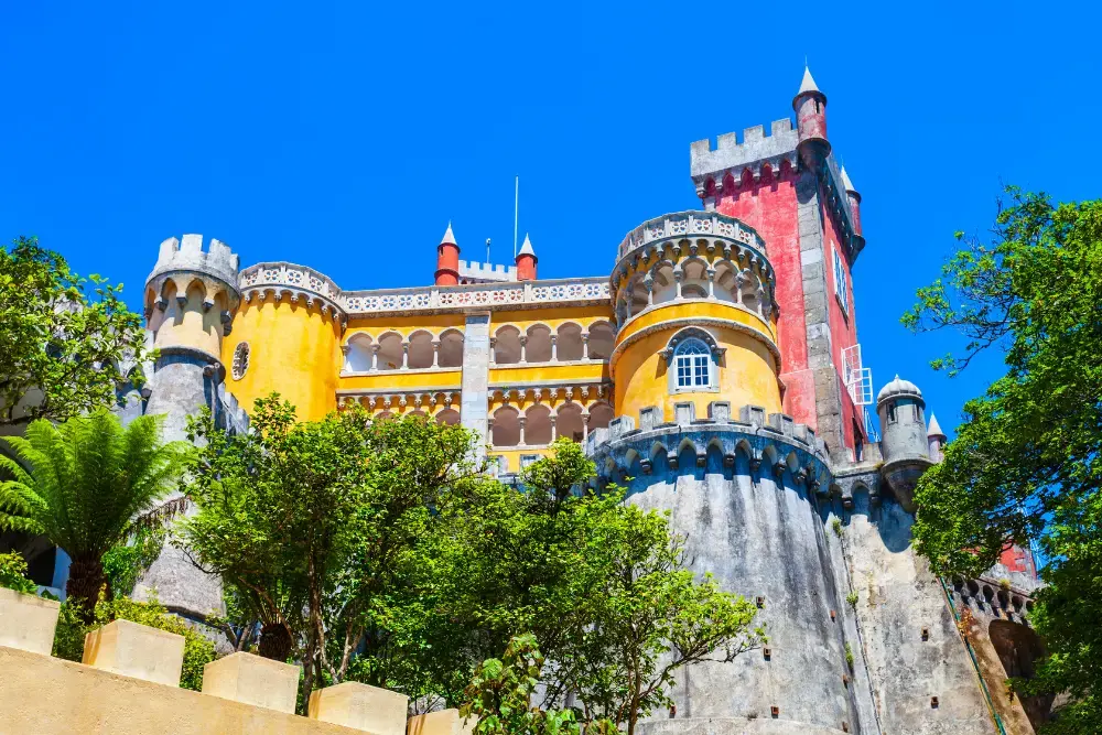 Colorido Palácio da Pena rodeado por jardins exuberantes em Sintra, Portugal, um dos monumentos mais icónicos do país
