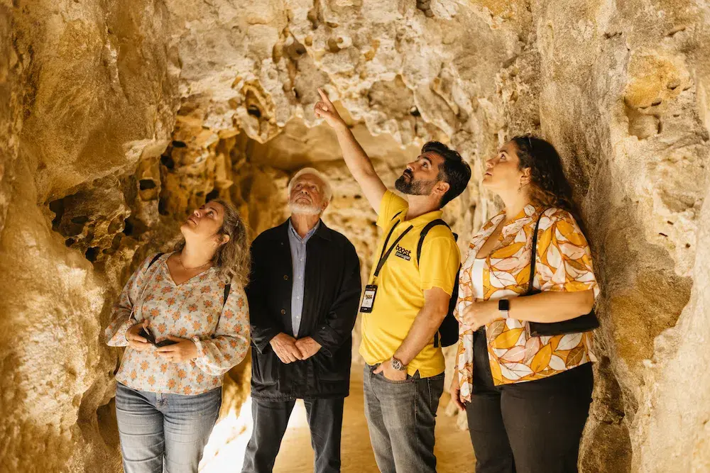 Visitantes a explorar os túneis subterrâneos da Quinta da Regaleira com um guia local em Sintra, Portugal