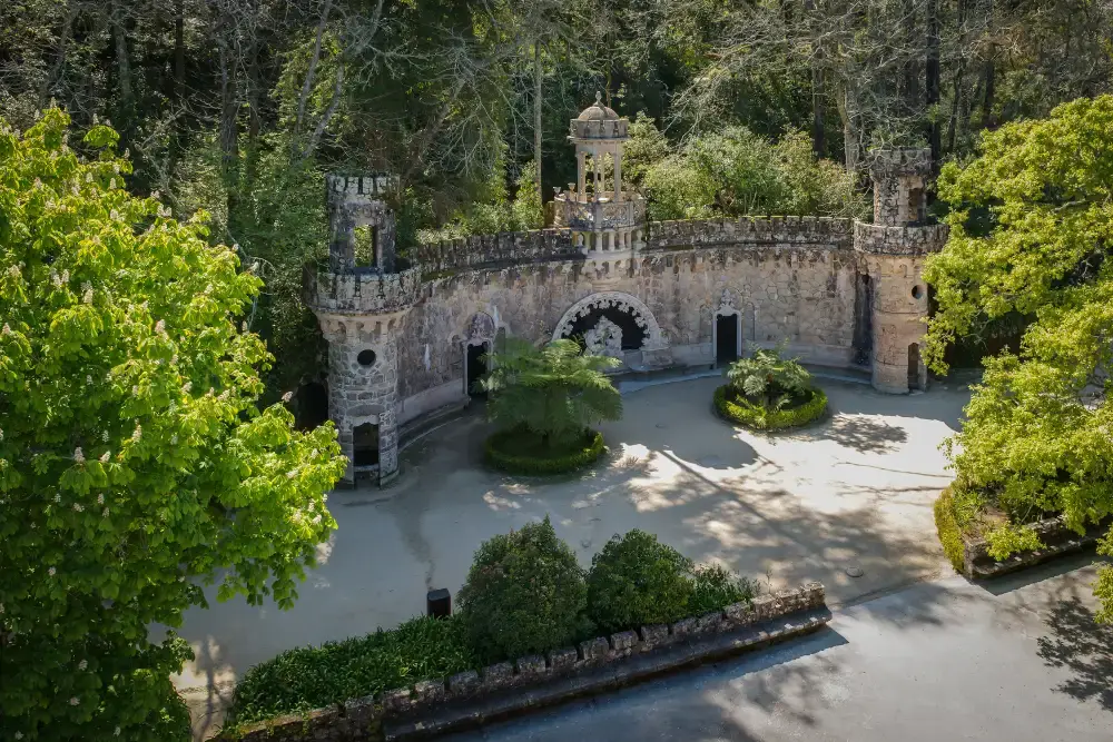 Aerial view of the Portal of the Guardians at Quinta da Regaleira surrounded by lush gardens in Sintra, Portugal